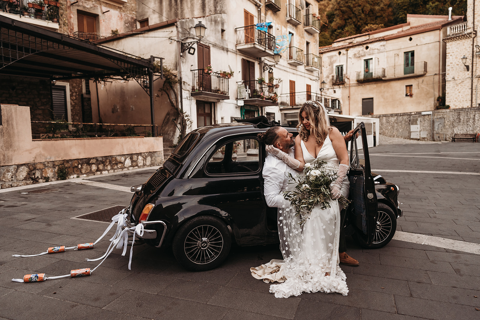 Italy wedding with vintage black Fiat 500 in rustic Italian village with bride and groom