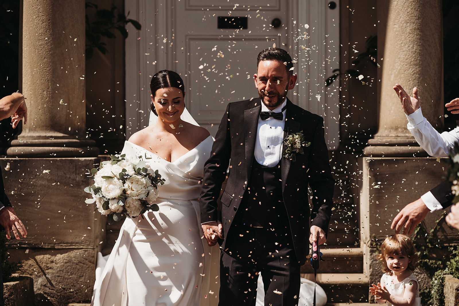 Bride and groom walking hand in hand during their cofetti moment at Shropshire wedding venue, Iscoyd Park