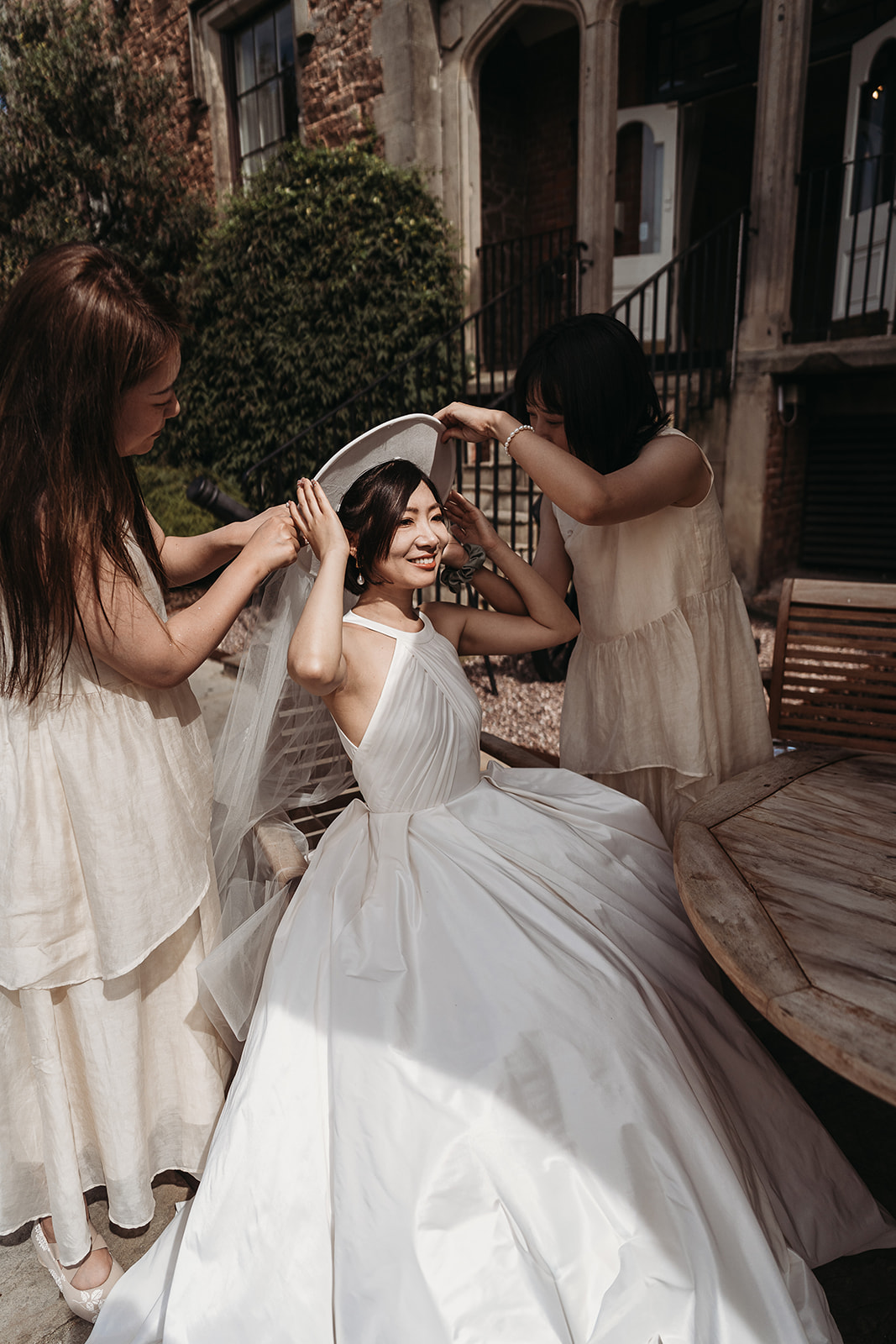 The bride sitting outside with the natural sunlight shining on her face at Shropshire wedding venue, Rowton Castle