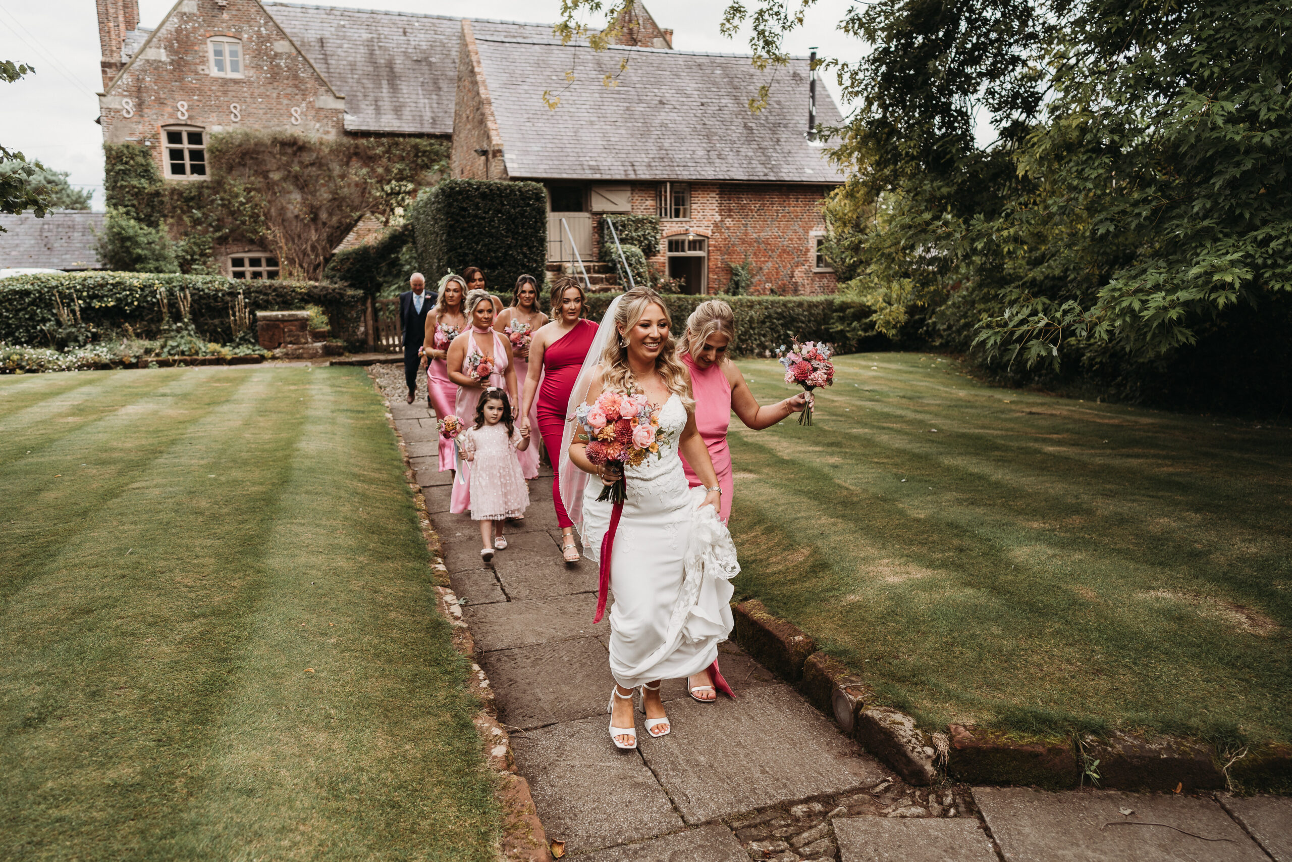 Bridal party dressed in hot pink bridesmaid dresses getting ready to leave for the wedding at Shropshire wedding venue, Pimhill Barn