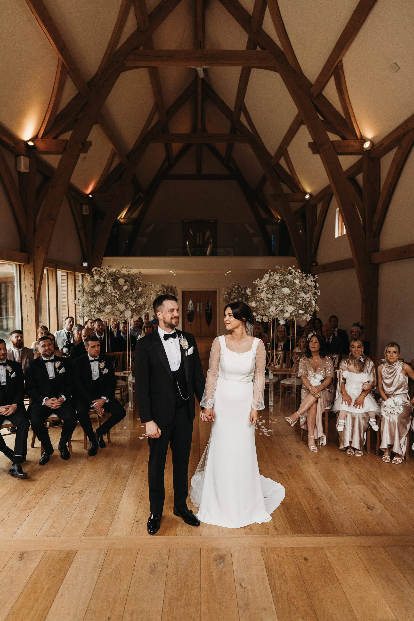 bride and groom with guests during ceremony at mill barns Shropshire wedding venue 