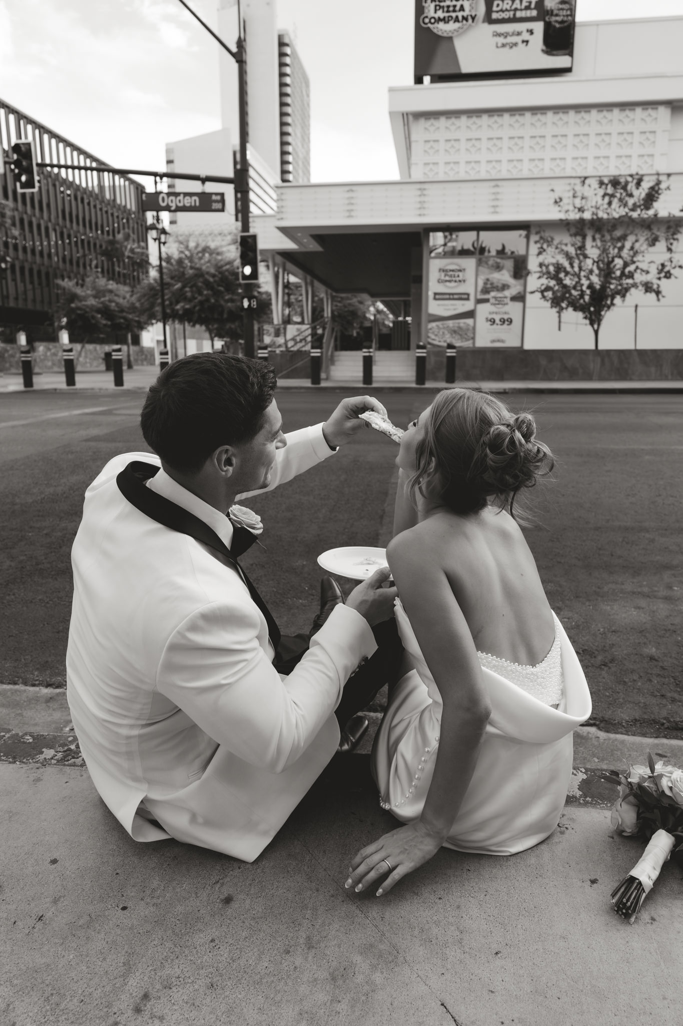 bride and groom eating pizza onna curb in las vegas